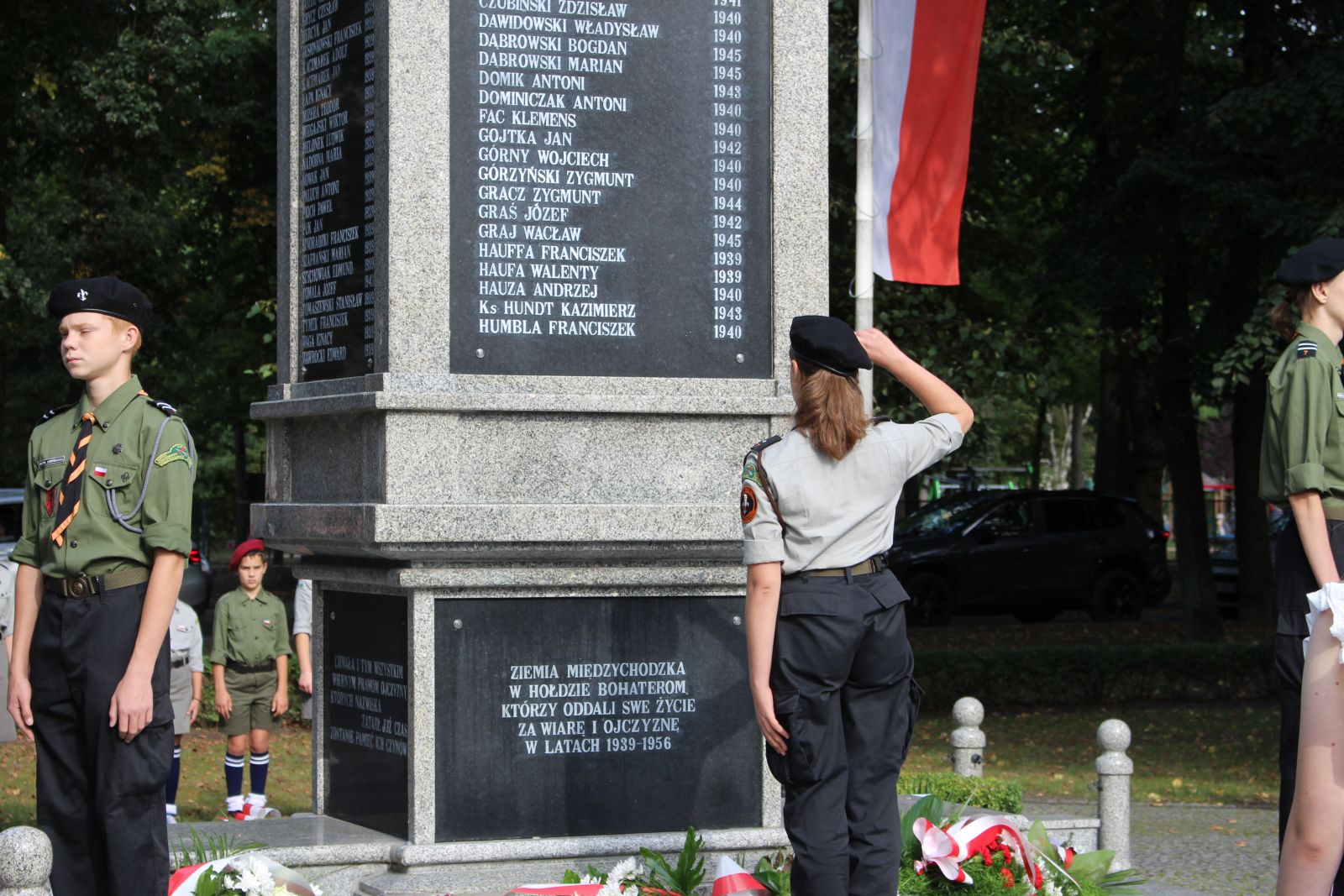 Harcerka salutuje zwrócona w stronę Pomnika Poległych i Pomordowanych w latach 1939-1956