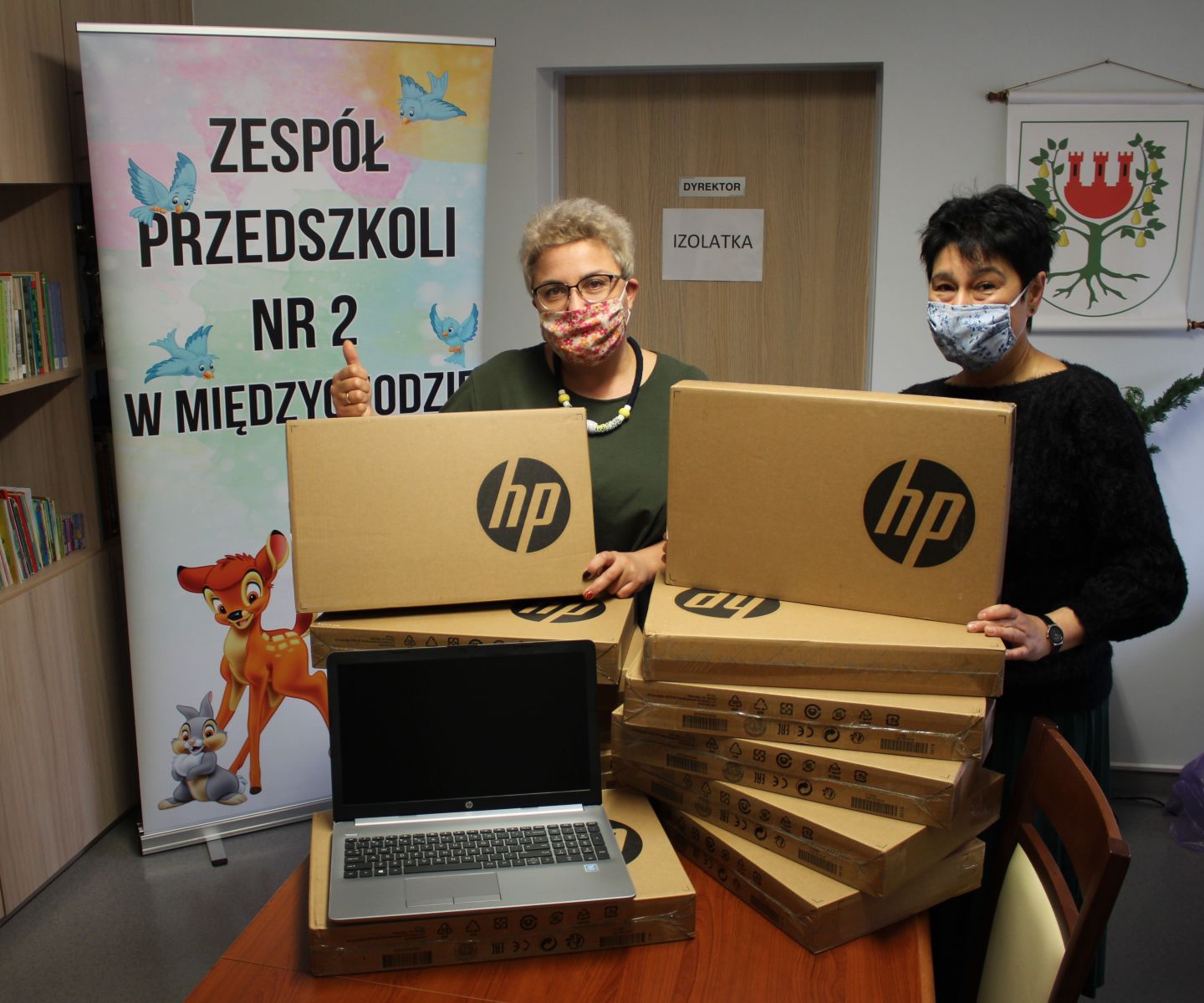 Na zdjęciu znajduje się Dyrektor oraz pracownik przedszkola z otrzymanymi laptopami. 
