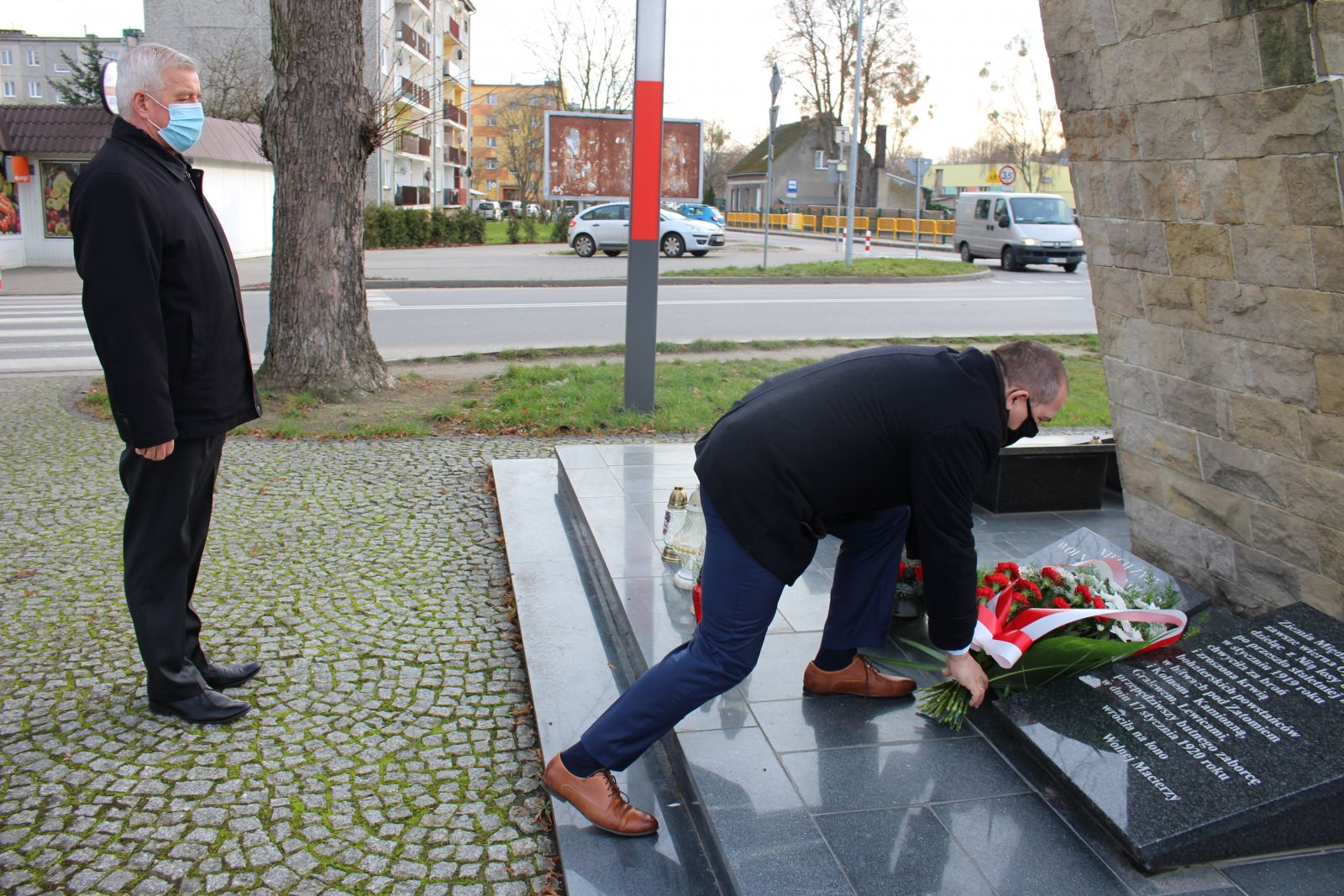 Zdjęcie przedstawia Krzysztofa Wolnego, który składa kwiaty pod Pomnikiem Powstańców Wielkopolskich